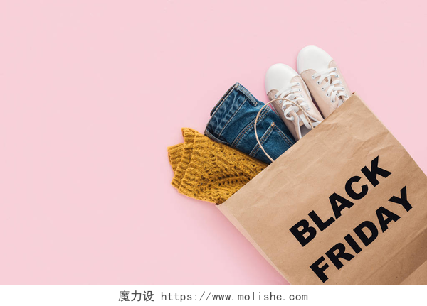 带有黑色星期五标志的袋子里的时尚衣服最热门的时尚服装在购物袋与黑色星期五标志被隔离粉红色